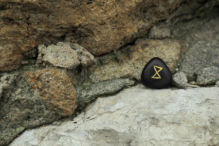 Black rune Dagaz on stone outdoors. Old Germanic alphabetの写真素材