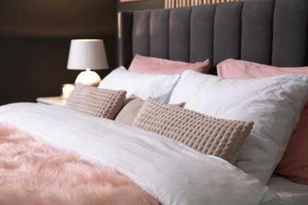 Comfortable bed with cushions in room. Stylish interiorの写真素材