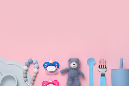 Flat lay composition with pacifiers and other baby stuff on pink background. Space for textの写真素材