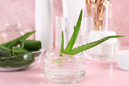 Jar of natural gel and aloe vera leaves on pink table, closeupの写真素材