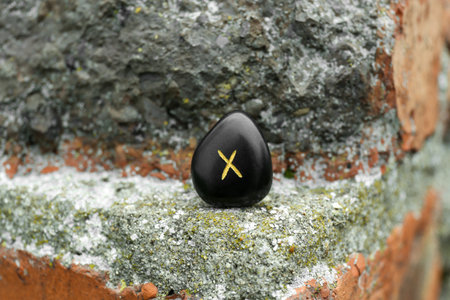 Black rune Gebo on stone outdoors, closeupの写真素材