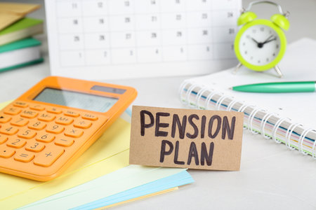 Card with words Pension Plan, calculator and stationery on white office table, closeupの写真素材