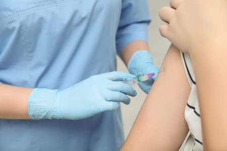 Doctor giving hepatitis vaccine to patient on gray background, closeupの写真素材