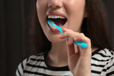 Woman brushing her teeth with plastic toothbrush in bathroom, closeupの写真素材