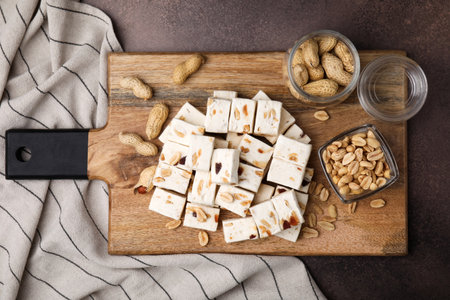 Pieces of delicious nutty nougat on brown table, top viewの写真素材