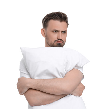 Unhappy man with pillow on white background. Insomnia problemの写真素材