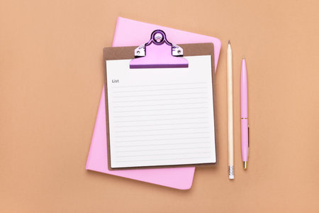 Clipboard with to do notes, planner, pen and pencil on brown background, flat lay. Space for textの写真素材