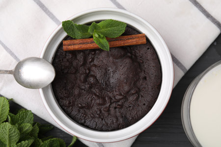 Tasty chocolate pie with mint and cinnamon stick on gray table, flat lay. Microwave cake recipe