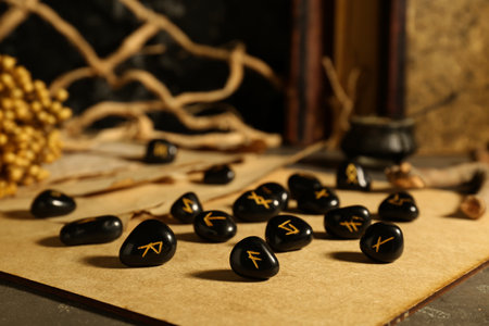 Wooden board with many black rune stones on tableの写真素材