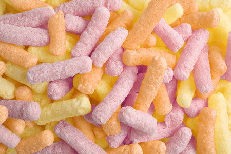 Many colorful corn puffs as background, top viewの写真素材