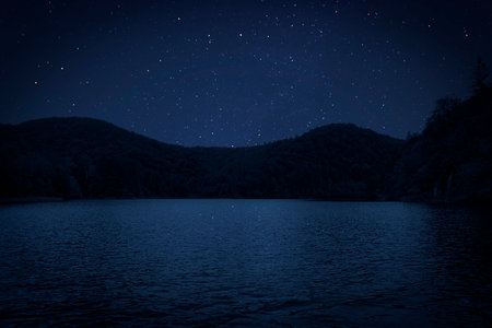 Amazing starry sky reflecting in lake. Beautiful night landscapeの写真素材