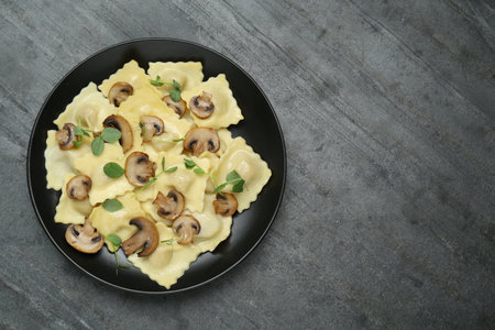 Delicious ravioli with mushrooms on gray table, top view. Space for textの写真素材