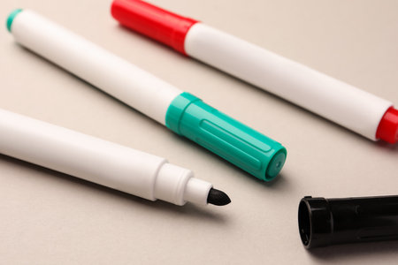 Bright color markers on beige background, closeup