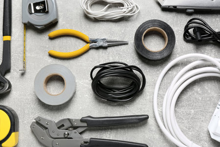 New wires and electrician's tools on gray table, flat layの写真素材