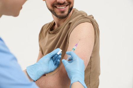 Doctor giving hepatitis vaccine to patient on white background, closeup