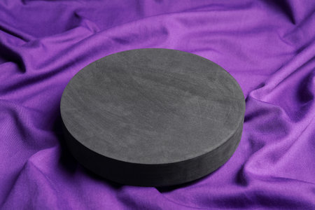 Black round stand on purple fabric, closeup. Stylish presentation for productの写真素材