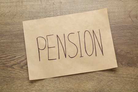 Card with word Pension on wooden table, top view