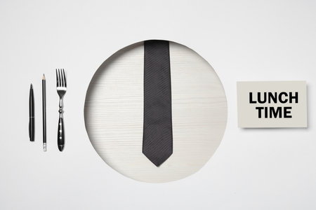 Creative business lunch layout. Composition with tie, stationery, fork and card on white background,...