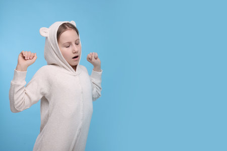 Sleepy girl yawning on light blue background, space for text. Insomnia problemの写真素材