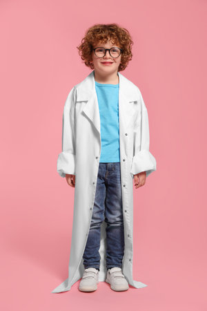 Full length portrait of little boy in medical uniform and glasses on pink backgroundの写真素材