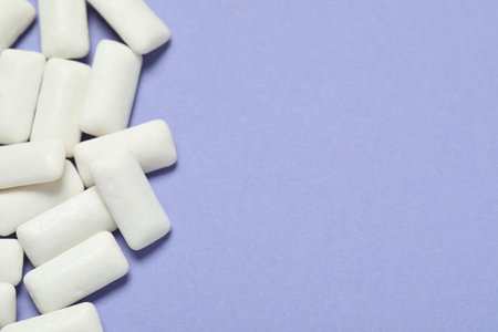 Tasty white chewing gums on light blue background, top view. Space for textの写真素材