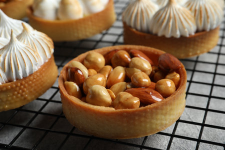 Many different tartlets on cooling tray, closeup. Tasty dessert