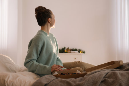 Woman with pizza watching movie via video projector at homeの写真素材