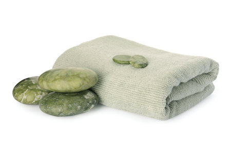 Composition with folded towel and spa stones on white backgroundの写真素材