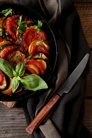 Delicious ratatouille and knife on table, flat layの写真素材