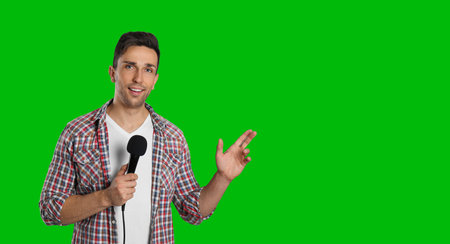 Chroma key compositing. Broadcaster with microphone against green screen, banner designの写真素材