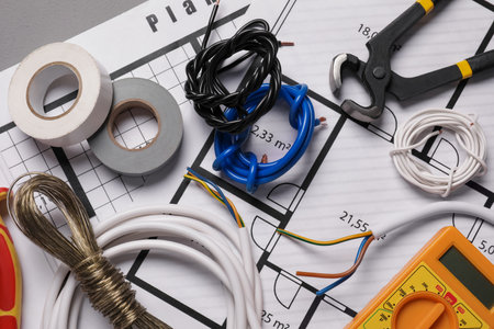 Different wires, tools and electrical schemes on gray table, closeupの写真素材