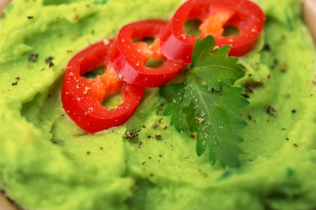 Delicious guacamole with chili pepper and parsley as background, closeupの写真素材