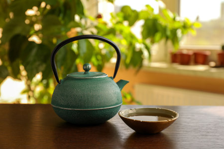 Teapot and cup of freshly brewed tea on wooden table indoors. traditional ceremonyの写真素材