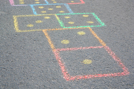 Hopscotch drawn with colorful chalk on asphalt outdoors, closeupの写真素材