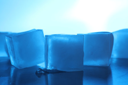 Crystal clear ice cubes on light blue background, closeup. Color tone effectの写真素材