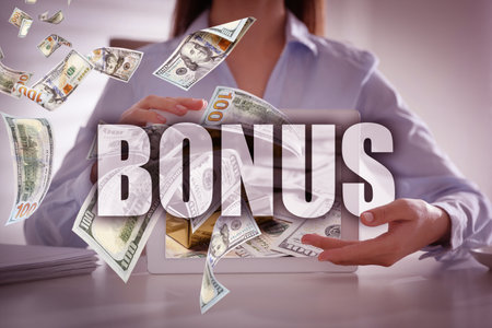 Bonus. Businesswoman holding tablet at table, closeup. Dollar banknotes flying from deviceの写真素材
