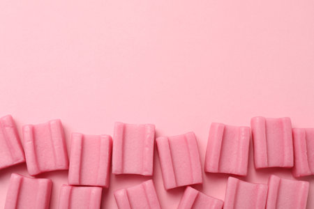 Tasty chewing gums on pink background, flat lay. Space for textの写真素材