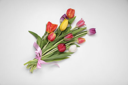 Bouquet of beautiful colorful tulips tied with pink ribbon on white background, top viewの写真素材