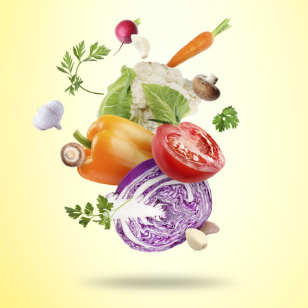 Many fresh vegetables, mushrooms and parsley falling on beige backgroundの写真素材