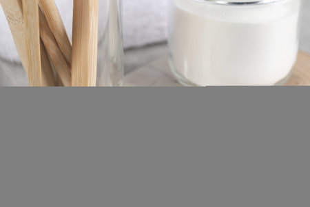 Bamboo toothbrushes and jar of baking soda on light gray table, closeupの写真素材