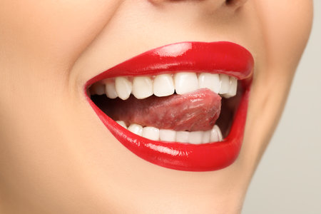 Woman showing her tongue on light background, closeupの写真素材