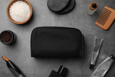 Compact toiletry bag, spa stones and different cosmetic products on gray textured background, flat layの写真素材