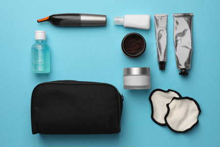 Preparation for spa. Compact toiletry bag with different cosmetic products on light blue background, flat layの写真素材