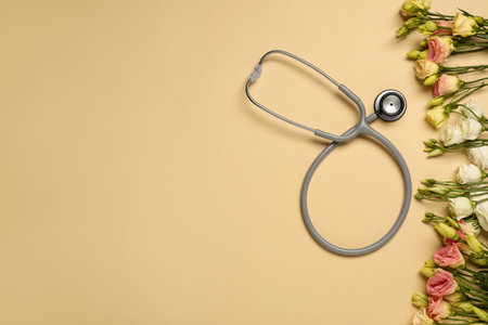 Stethoscope and flowers on dark beige background, flat lay with space for text. Happy Doctor's Dayの写真素材