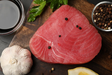 Raw tuna fillet, spices and soy sauce on wooden board, top viewの写真素材