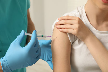 Doctor giving hepatitis vaccine to patient, closeupの写真素材