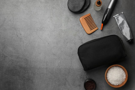 Compact toiletry bag, spa stones and different cosmetic products on gray textured background, flat lay. Space for textの写真素材