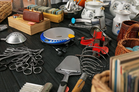 Many different stuff on black wooden table. Garage sale