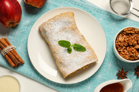 Delicious strudel with apples and ingredients on white table, flat layの写真素材