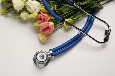Stethoscope and flowers on white background. Happy Doctor's Dayの写真素材